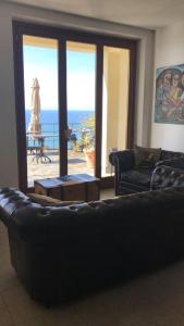 a living room with a couch and a view of the ocean at Albergo Luna di Marzo in Volastra