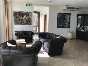a living room with two leather couches and a table at Albergo Luna di Marzo in Volastra