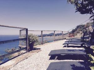 a row of benches sitting on the side of a cliff at Albergo Luna di Marzo in Volastra