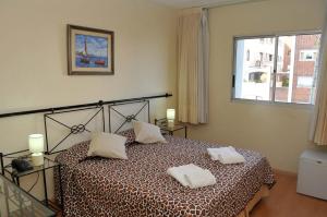 een slaapkamer met een bed met 2 kussens erop bij Hotel Marbella in Punta del Este
