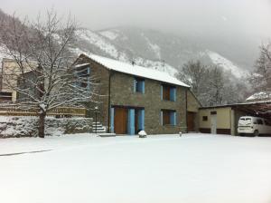 une maison dans la neige avec une cour recouverte de neige dans l'établissement Apartamentos La Era, à Sorripas