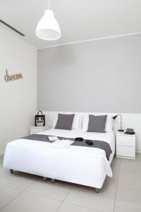 a white bedroom with a large white bed and white walls at Palazzo Talenti 1907 in Trieste