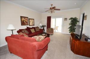 a living room with a red couch and a tv at 1011 Willow Bend Condo in North Myrtle Beach