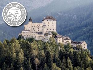 a castle on top of a hill with trees at Engadiner Boutique-Hotel GuardaVal in Scuol