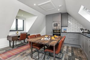 a kitchen with a wooden table and some chairs at Paddock View in Winchester