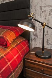 a lamp on a night stand next to a bed at Paddock View in Winchester