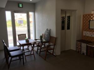 a dining room with a table and chairs and a window at Mr KINJO in 西原インター in Ginowan