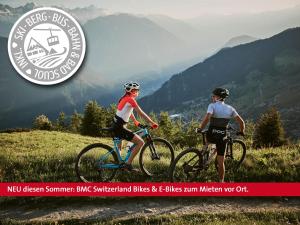 duas pessoas a andar de bicicleta num trilho de montanha em Engadiner Boutique-Hotel GuardaVal em Scuol