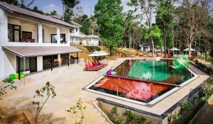 an image of a swimming pool in front of a house at Sterling Wayanad in Sultan Bathery