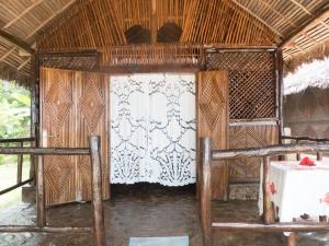 Habitación con cama y mesa en una cabaña en Le Zahir de l'ile - Iranja, en Nosy Be