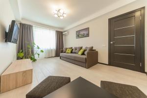 a living room with a couch and a television at ARTAL Apartment on Iordanskaya 22 in Kyiv
