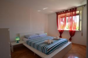 a bedroom with a bed and a window with red curtains at Apartman Terzić in Rovinj