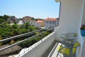 a balcony with a table and chairs and a view at Apartman Terzić in Rovinj