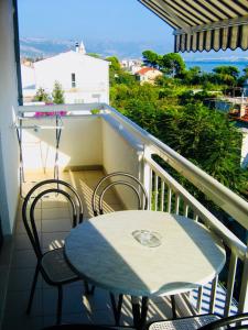 a table and chairs on a balcony with a view at Apartments Ruza in Kaštela