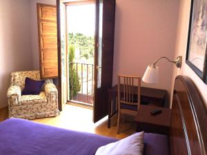 1 dormitorio con cama, escritorio y ventana en Hospedaje La Judería, en Segovia