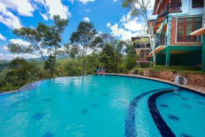 a swimming pool at a resort with blue water at Tina Nature villa in Ella