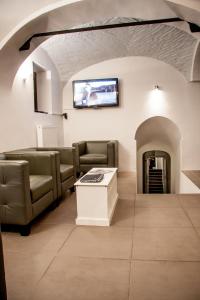 uma sala de estar com sofás e uma televisão na parede em 4Rooms em Maribor
