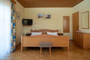 1 dormitorio con cama de madera y TV en Bauernhof Flucher-Plaschg en Straden