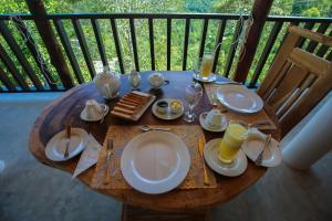 a wooden table with plates of food on a balcony at Tina Nature villa in Ella