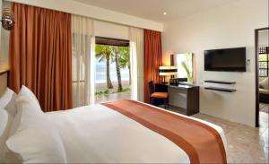 a bedroom with a bed and a desk and a television at Oceanica Resort Panglao, Bohol in Panglao