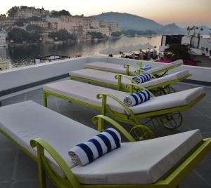a row of chairs with umbrellas on a beach at Lake Pichola Hotel in Udaipur