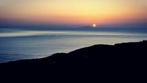 a sunset over the ocean with the sun in the sky at Dammuso Libeccio in Pantelleria
