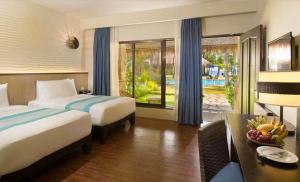 a hotel room with two beds and a desk and a table with a tablektop at Oceanica Resort Panglao, Bohol in Panglao +65 photos