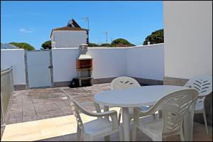 a white table and chairs on a balcony with a table and a fence at Casa Rural Zara II in Conil de la Frontera