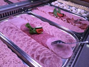 a display case with several trays of food with meat at Jugendherberge Berchtesgaden in Berchtesgaden