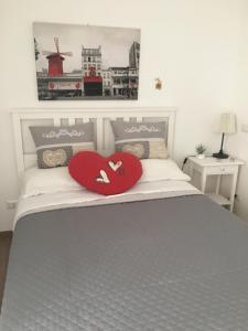 a bed with two red heart pillows on it at The shabby house in Anzio