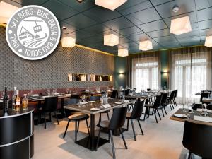 a restaurant with tables and chairs and a sign on the wall at Badehotel Belvair in Scuol