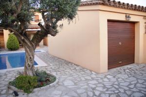 a garage with a tree next to a house at Villashim in L'Escala