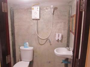 a bathroom with a shower and a toilet and a sink at Baan Thung Home Stay in Prasat +105 photos