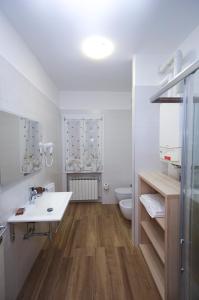 uma casa de banho branca com um lavatório e um WC em Venice Loft em Marghera