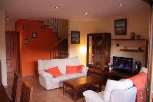 een woonkamer met een witte bank en een tv bij Villashim in L'Escala