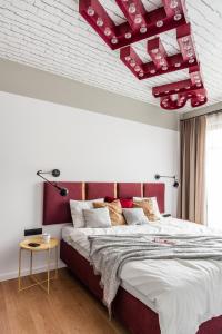 イェリトコボにあるDom & House - Apartments Neptun Park Premiumのベッドルーム1室(赤いヘッドボード付きの大型ベッド1台付)