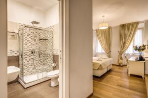 1 cama y baño con aseo y ducha. en Gravina Suite Frattina, en Roma