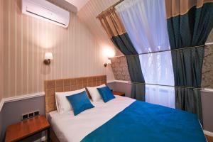 モスクワにあるMarkell Hotelのベッドルーム1室(青い枕のベッド1台、窓付)