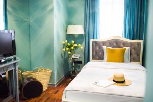 a bedroom with a bed with a hat on it at Vintage Boutique Hotel in Lviv