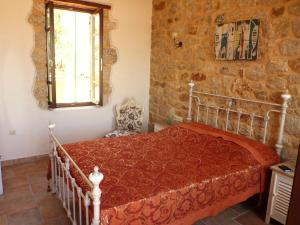 um quarto com uma cama numa parede de pedra em Bright Sun Villas em Halki