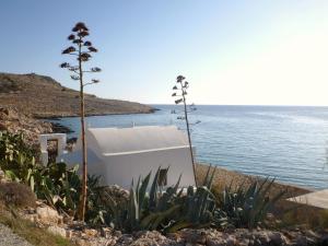 a white building on the side of the water at Bright Sun Villas in Halki