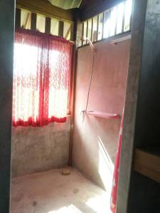 een kleine kamer met een raam en een gordijn bij Jansom Bungalow 2 in Ko Phayam