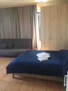 a bedroom with a blue bed with towels on it at Teris Appartment in Preveza