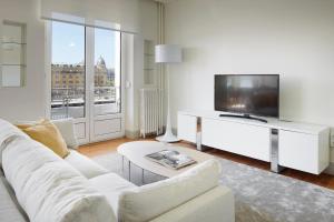 a living room with a white couch and a tv at Okendo by FeelFree Rentals in San Sebasti&aacute;n