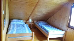 two beds in a room with a attic at Domek letniskowy Młyn in Karwieńskie Błoto Pierwsze
