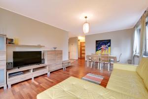 a living room with a couch and a television at Apartamenty Apartinfo Na Wydmie in Jurata