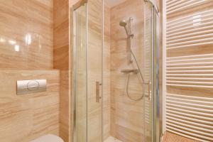 a bathroom with a shower with a toilet at Apartamenty Apartinfo Na Wydmie in Jurata