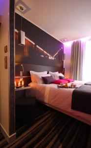 a bedroom with a large bed with purple lighting at Hôtel Lumières Montmartre Paris in Paris