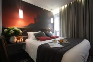 Ένα ή περισσότερα κρεβάτια σε δωμάτιο στο Hôtel Lumières Montmartre Paris