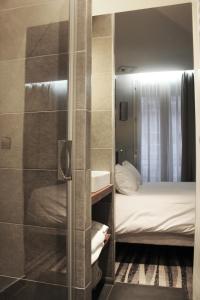 ein Bad mit Dusche und ein Bett in einem Zimmer in der Unterkunft Hôtel Lumières Montmartre Paris in Paris